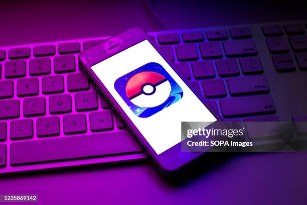 In this photo illustration a Pokemon GO logo seen displayed on a smartphone on top of a computer keyboard.