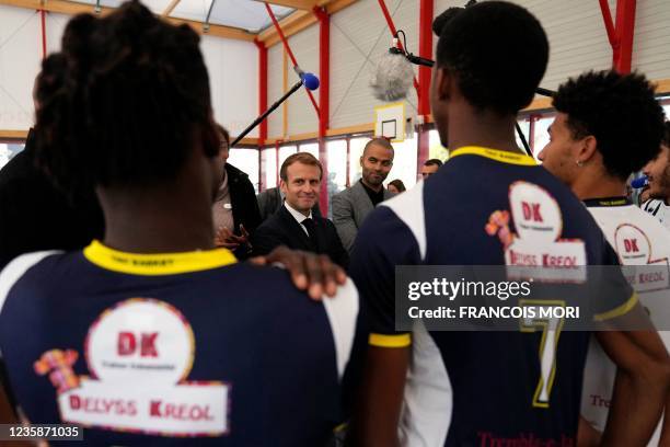 French President Emmanuel Macron , accompanied by former French-US basketball player Tony Parker , meets youth of a basketball team in...