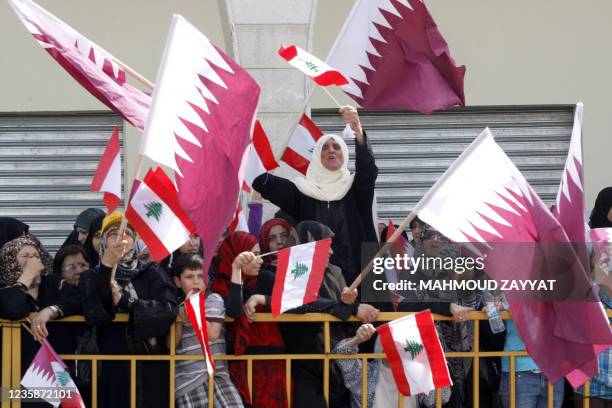 Residents of Bint Jbeil wave Lebanese and Qatari flags as Qatar's Emir Sheikh Hamad bin Khalifa al-Thani tours reconstruction efforts, partially...