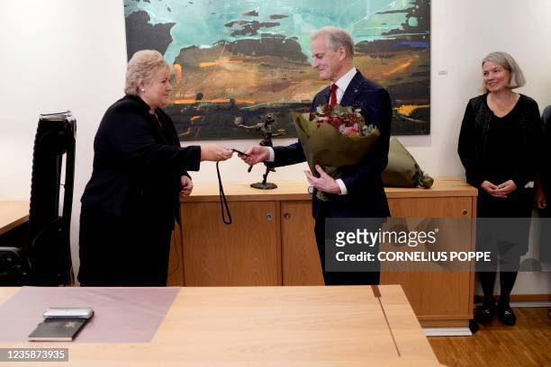 Norway's outgoing Prime Minister Erna Solberg hands over the key to the Prime Minister's office to the new Prime Minister Jonas Gahr Store in Oslo,...