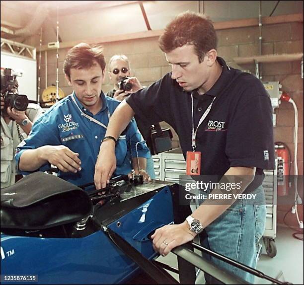 Le pilote français de l'écurie Prost-Mugen-Honda, Olivier Panis, discute avec un technicien dans les stands du circuit de Spa-Francorchamps, le 21...