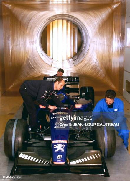 Des mécaniciens de l'équipe "Prost Grand Prix" s'affairent sur la Formule Un AP02, le 05 mai 1999 dans les locaux de l'Office national d'études et de...