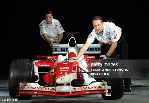 Des mécaniciens poussent la TF103, nouvelle monoplace Formule 1 pour la saison 2003 du constructeur automobile japonais Toyota, le 08 janvier 2003 au...