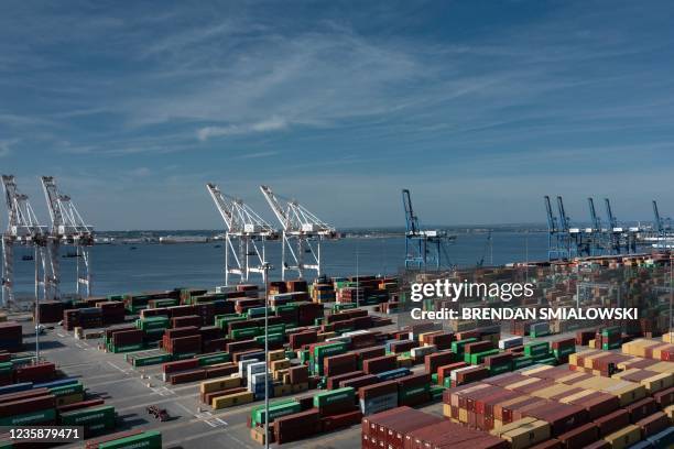 Cargo containers are readied for transport at the Port of Baltimore in Baltimore, Maryland, on October 14, 2021. Closed factories, clogged ports, no...