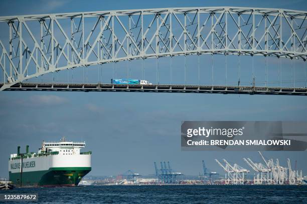 Cargo ship passes below the Francis Scott Key Bridge while leaving the Port of Baltimore October 14 in Baltimore, Maryland. Closed factories, clogged...