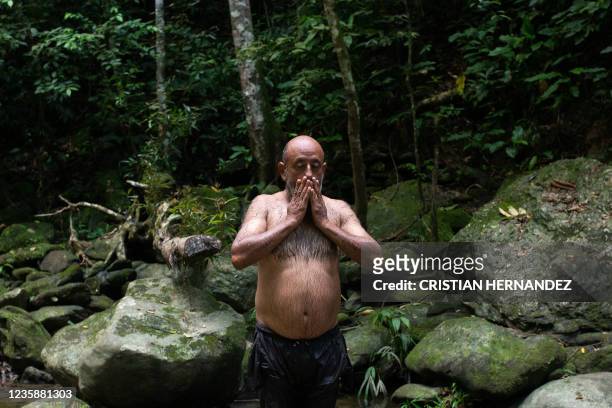 Graphic content / A man takes a spiritual bath in the Yaracuy River on the Sorte mountain in Yaracuy state, Venezuela, on October 10, 2021. - On...