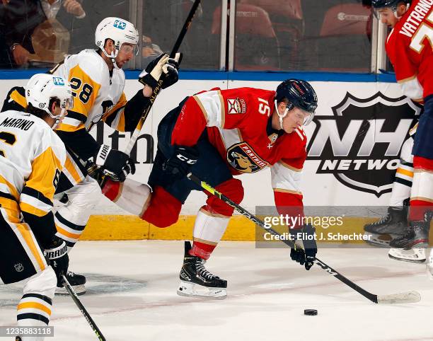 Anton Lundell of the Florida Panthers skates for possession against Marcus Pettersson of the Pittsburg Penguins at the FLA Live Arena on October 14,...