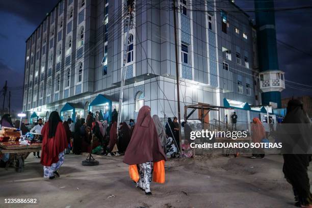 People walk in front of a mosque, in the city of Hargeisa, Somaliland , on September 16, 2021.
