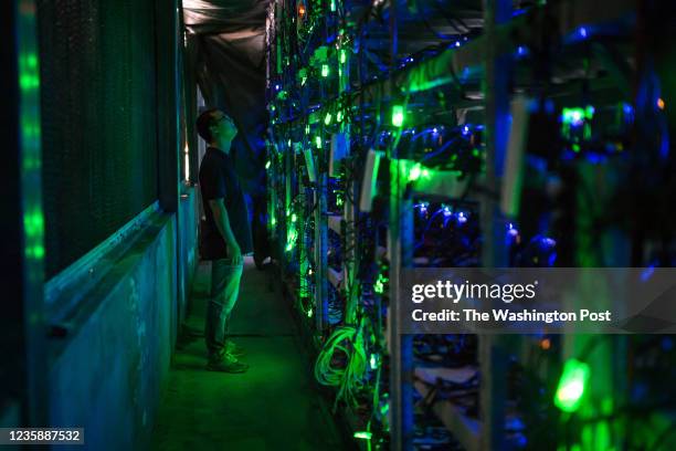 Haobtc's bitcoin mine site manager, Guo-hua, checks mining equipment inside their bitcoin mine near Kongyuxiang, Sichuan, China.