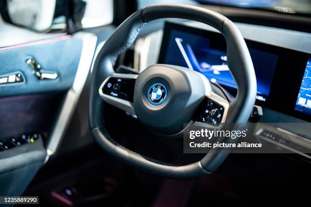 September 2021, Bavaria, Garching: The cockpit of a BMW iX with a flattened two-spoke steering wheel and large displays is seen inside the car during...