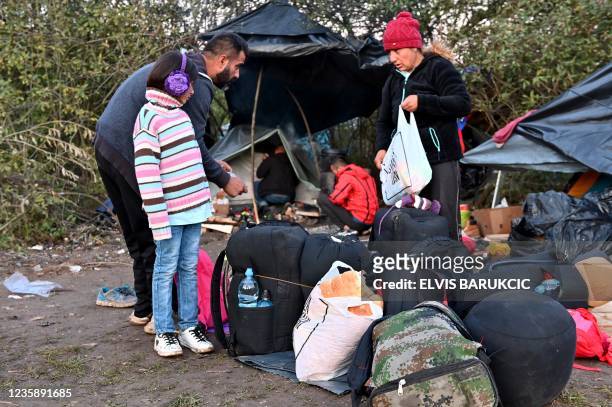 Members of an Afghan familly pack their belongings as they prepare to cross Croatian border near their illegal improvised camp, outside...