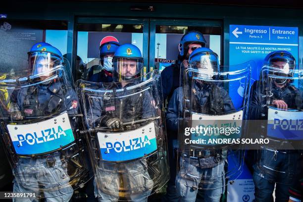 Anti-riot police officers stand guard at an entrance to Terminal 1 as employees of Italian airline Alitalia stage a protest of Rome's Fiumicino...