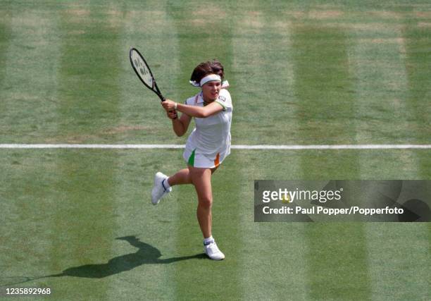 Martina Hingis of Switzerland returns the ball against Jana Novotna of the Czech Republic during the women's final on day thirteen of the Wimbledon...