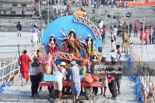 Municipal laborers carry an idol of Hindu goddess Durga to immerse into the river Brahmaputra during Durga Puja festivities in Guwahati ,India on...