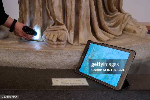 Restoration specialist checks the condition of the Athena sculpture at the National Archaeological Museum of Naples with a Dinolight instrument.