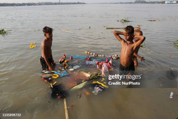 Ragpickers collects Hindu goddess structures after into Ganges River by Hindu devotees during immersion of Durga idols, in Kolkata, India, Oct. 15,...