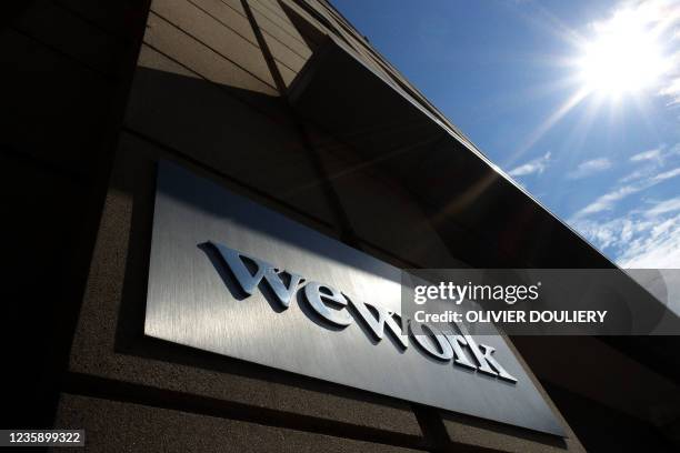 WeWork sign in front of a building in Arlington, Virginia on October 15, 2021. - WeWork is to go public in special purpose acquistion valued at $9...