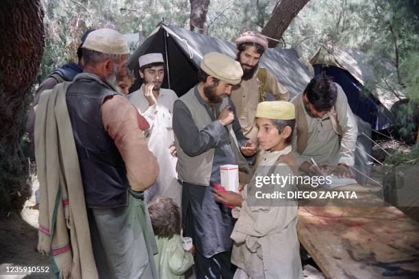 Afghan relief workers bring food and medical supplies at the first-aid post of Ghaziabad District, Kunar, during the Afghan Civil War, on April 27,...