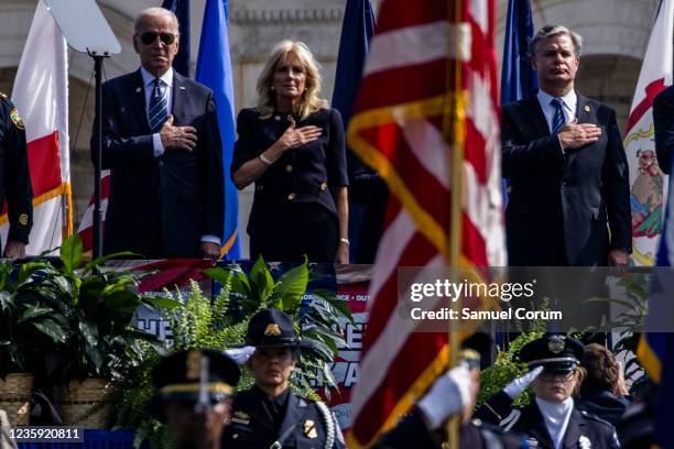President Joe Biden, First Lady Jill Biden, and Federal Bureau of Investigation Director Christopher Wray stand during the U.S. National Anthem at...
