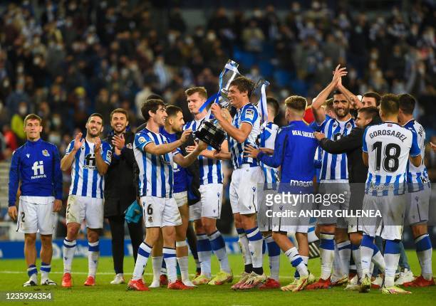 Real Sociedad's players celebrate with the trophy of the 2020 Spanish Copa del Rey after winning the Spanish League football match between Real...