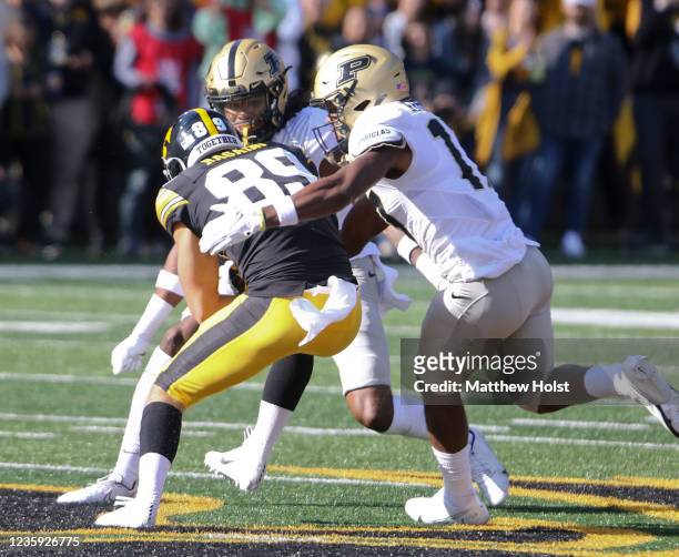 Wide receiver Nico Ragaini of the Iowa Hawkeyes is wrapped up during the first half by safety Marvin Grant and safety Chris Johnson of the Purdue...