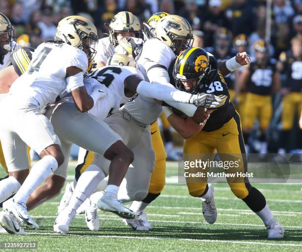 Fullback Monte Pottebaum of the Iowa Hawkeyes goes up the field during the first half against defensive tackle Lawrence Johnson of the Purdue...