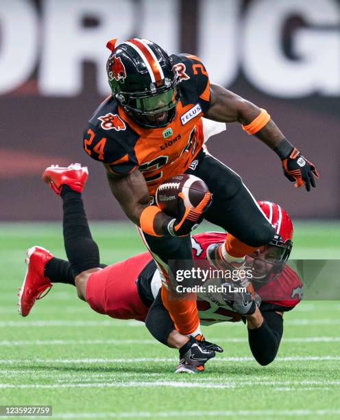 James Butler of the BC Lions gets tackled by Jonathan Moxey of the Calgary Stampeders during the first half of CFL football action at BC Place on...