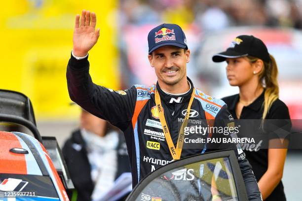 Third-placed Spain's driver Dani Sordo of Hyundai Shell Mobis World Rally, competing with a Hyundai I20 Coupe WRC, waves during the podium ceremony...