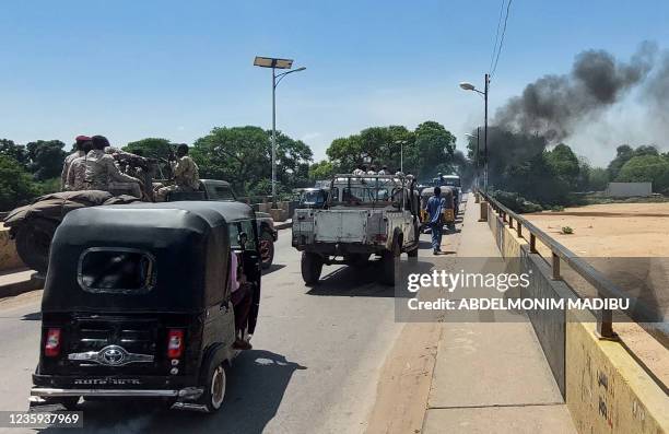 Sudanese security forces intervene as smoke billows from tyres set on fire by Sudanese students demonstrating against the hikes in bread prices due...