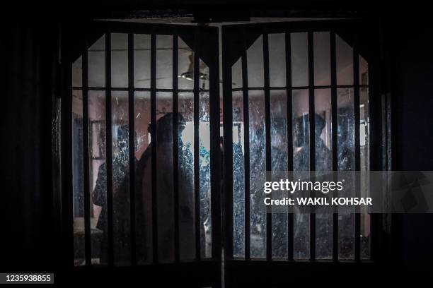 Taliban members are seen from a window as they inspect inside a prison cell at Pul-e-Charkhi prison, located on the outskirts of Kabul on October 17,...