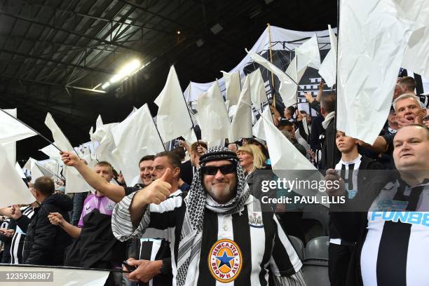 Newcastle United fans wave black and white flags and banners celebrating the club's recent take over by a Saudi-led consortium during the English...