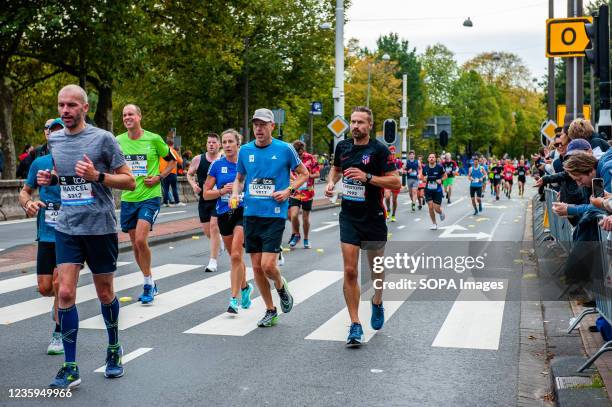 Group of male runners is seen looking exhausted during the last kilometers. Last year, the marathon was canceled due to the coronavirus, but with...