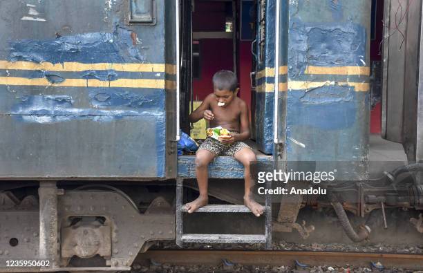 Porter boy has lunch at the Chittagong railway station area on October 13, 2021. Porters live at the station with their families. They live on what...