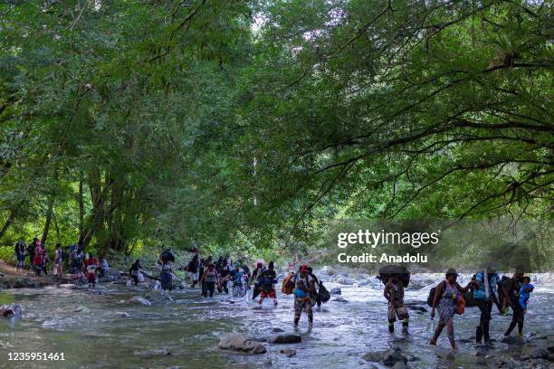 Migrants, most of them Haitians, cross a dead river in the border between Colombia and Panama on October 15, 2021 in Darien, Panama. There are more...