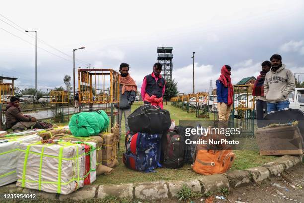 Non-Local Laborers wait outside a Railway Station with all their belongings in Sopore, District Baramulla, Jammu and Kashmir, India on 18 October...