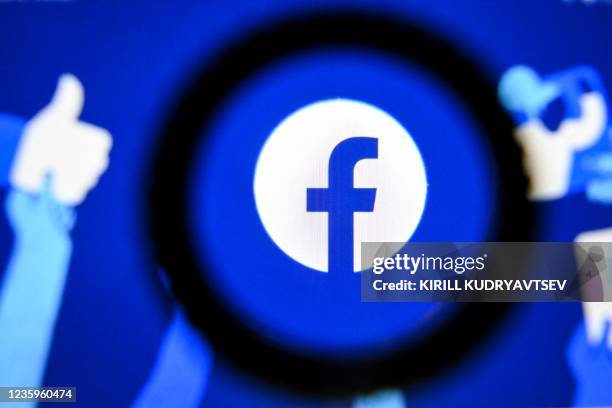 Photo taken on October 18, 2021 in Moscow shows the US online social media and social networking service Facebook's logo on a tablet screen. -...