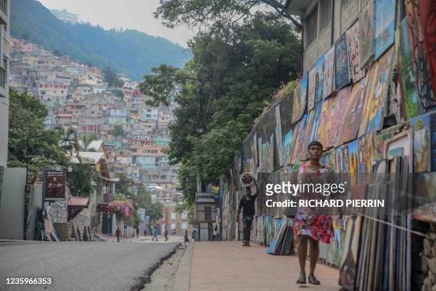 Couple of people walk in the deserted street in Port-au-Prince on October 18, 2021. - A nationwide general strike emptied the streets of Haiti's...