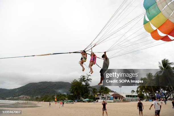 Parasailing on Patong Beach. Thailands Phuket Island has a 7 day quarantine period for vaccinated foreign tourists and locals, called the Phuket...