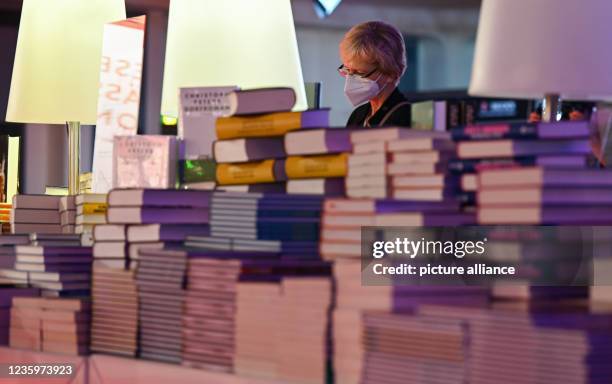 October 2021, Hessen, Frankfurt/Main: A woman stands in front of a pile of books on the sidelines of the Book Fair's opening press conference in the...