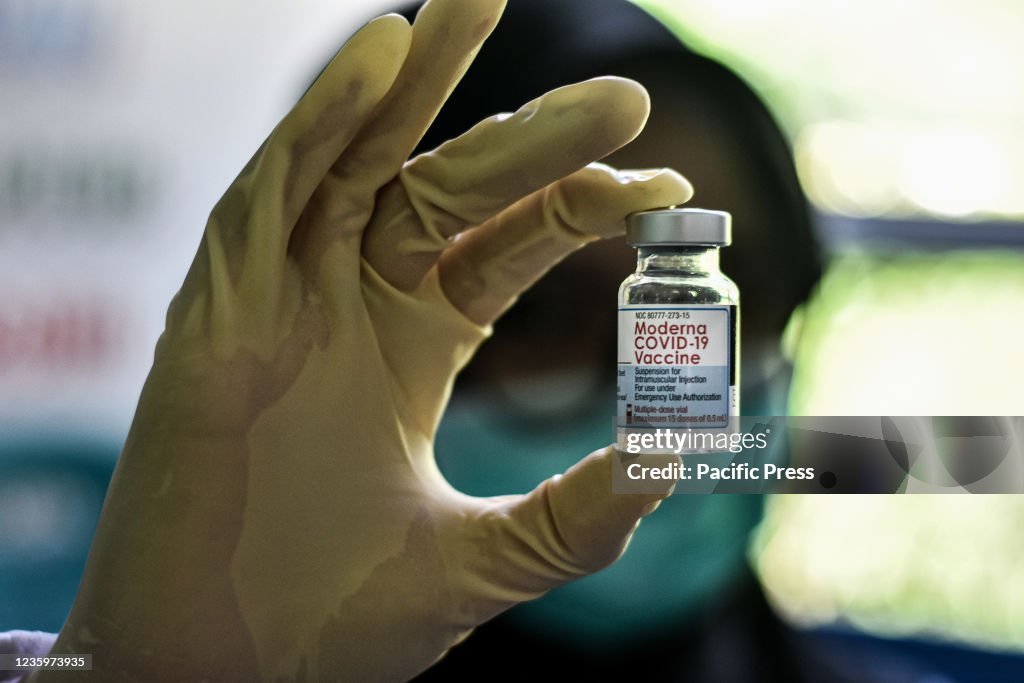 A health worker shows a bottle of moderna covid-19 vaccine...