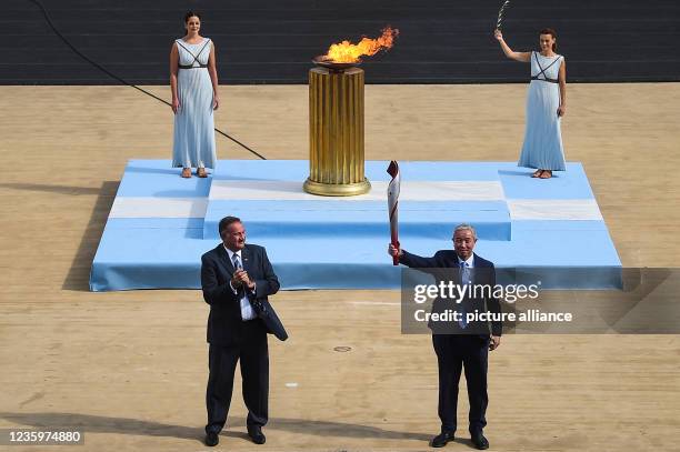 October 2021, Greece, Athen: Yu Zaiqing , vice president of the Chinese Olympic Committee, holds the torch during the ceremony to hand over the flame...
