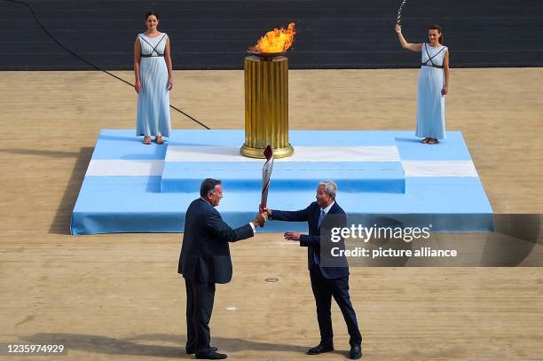 October 2021, Greece, Athen: Spyros Kapralos , President of the Greek Olympic Committee, hands over the torch to Yu Zaiqing, Vice-President of the...