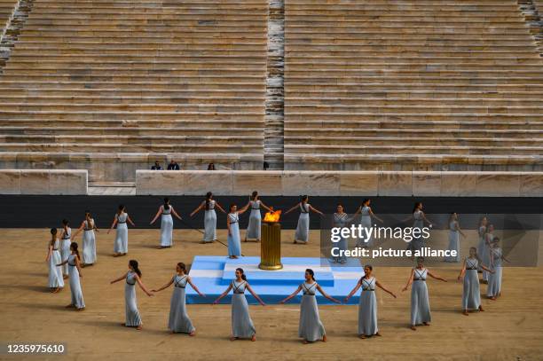 October 2021, Greece, Athen: Performers appear as priestesses during the ceremony to hand over the flame for the 2022 Winter Olympics in Athens at...