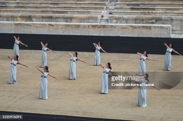 October 2021, Greece, Athen: Performers appear as priestesses during the ceremony to hand over the flame for the 2022 Winter Olympics in Athens at...