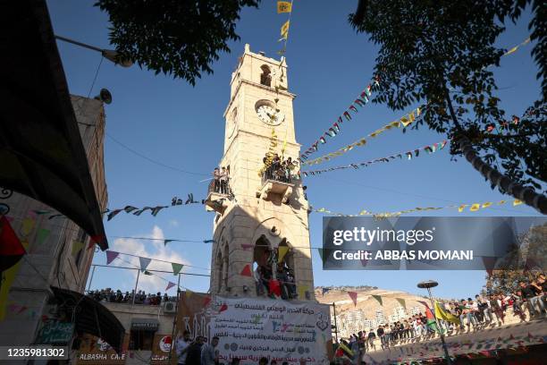 Palestinians gather in and around the Manara clock tower in the West Bank city of Nablus, as they celebrate the birth anniversary of Islam's Prophet...