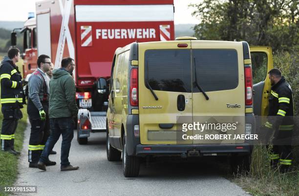 Austrian firemen inspect the van where two migrants were discovered dead during a control near the Austrian-Hungarian border near Siegendorf,...
