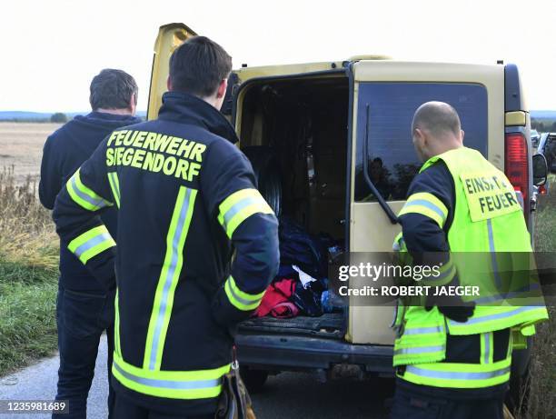Austrian firemen inspect the van where two migrants were discovered dead during a control near the Austrian-Hungarian border near Siegendorf,...