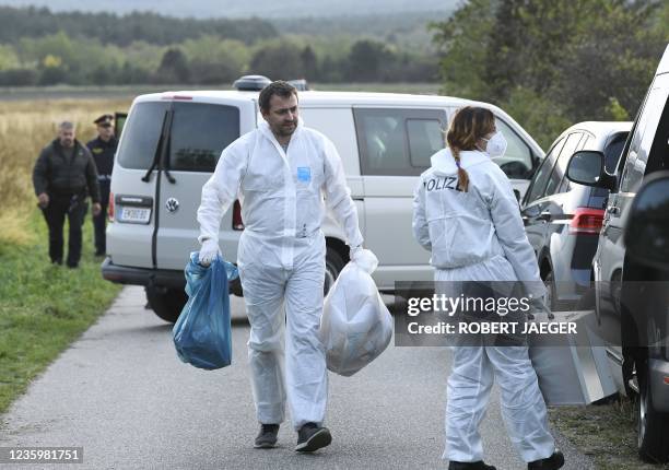 Austrian police carry bags near the Austrian-Hungarian border near Siegendorf, Burgenland, Eisenstadt district, on October 19 where two migrants were...