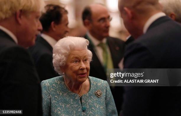 Britain's Queen Elizabeth II and Britain's Prime Minister Boris Johnson greet guests during a reception to mark the Global Investment Summit, at...
