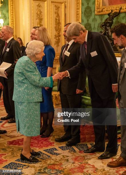 Britain's Queen Elizabeth II greets John Kerry, United States Special Presidential Envoy for Climate during a reception for international business...
